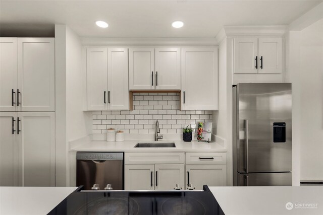 kitchen with white cabinetry, backsplash, stainless steel appliances, and sink