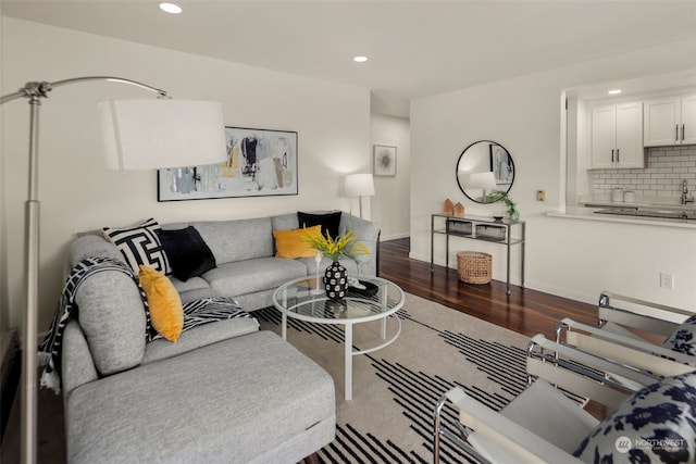 living room featuring recessed lighting, dark wood-type flooring, and baseboards