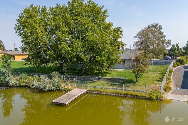 dock area featuring a water view and a lawn