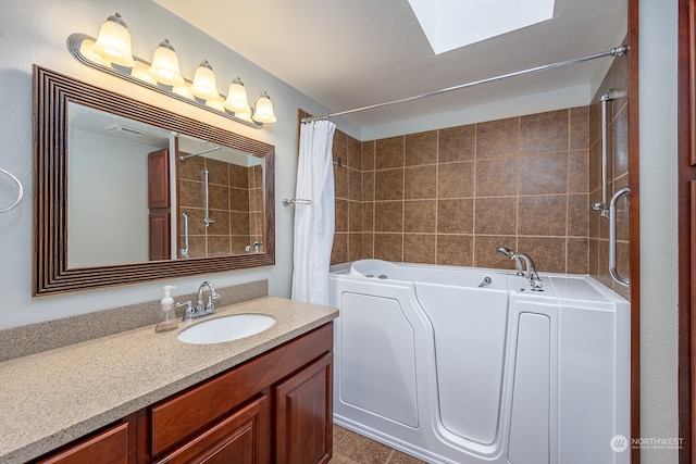 bathroom featuring tile patterned floors, a skylight, and vanity