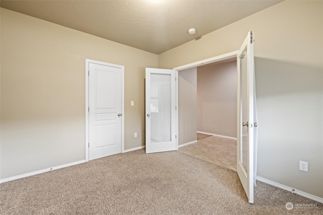 unfurnished bedroom with a textured ceiling and carpet flooring