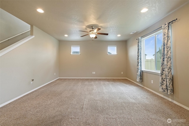 carpeted empty room featuring ceiling fan and a textured ceiling