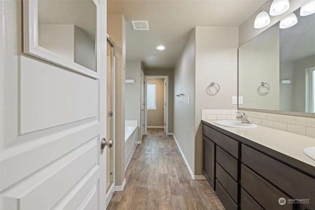 bathroom featuring a tub to relax in, hardwood / wood-style flooring, and vanity