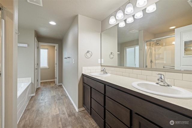 bathroom featuring vanity, separate shower and tub, decorative backsplash, and hardwood / wood-style flooring