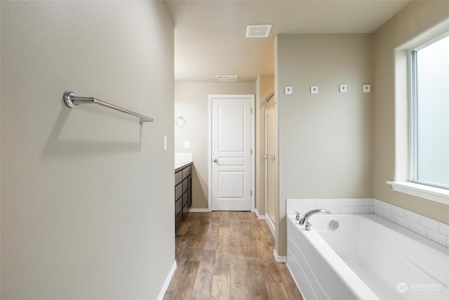 bathroom featuring a wealth of natural light, hardwood / wood-style flooring, vanity, and separate shower and tub