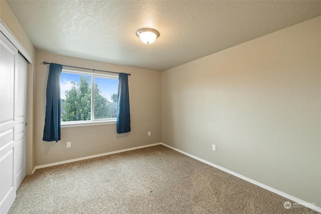 spare room with carpet floors and a textured ceiling