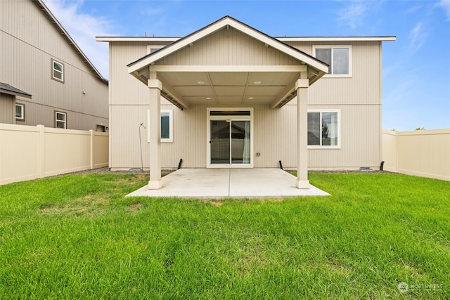 rear view of house featuring a lawn and a patio