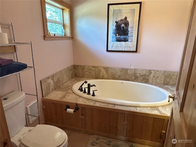 bathroom with tile patterned flooring, a bath, and toilet