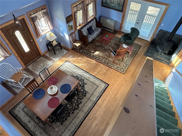 living room with hardwood / wood-style flooring, plenty of natural light, a wood stove, and french doors