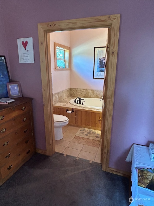 bathroom featuring tile patterned flooring, a bath, and toilet