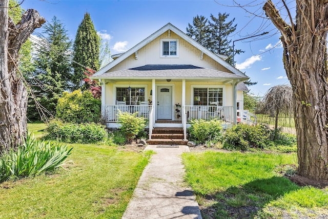 bungalow-style house with a front yard and covered porch