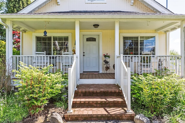 view of exterior entry featuring covered porch