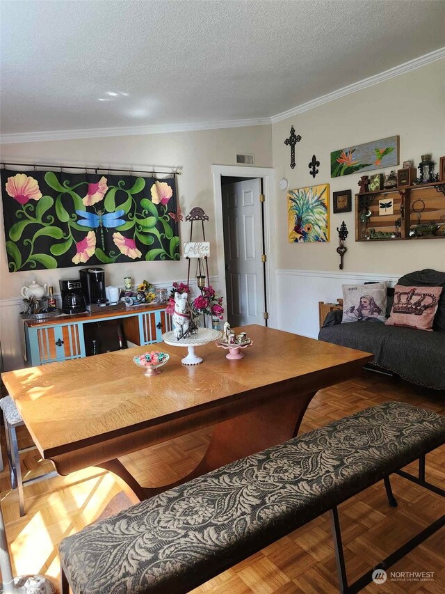 dining area featuring a textured ceiling and ornamental molding