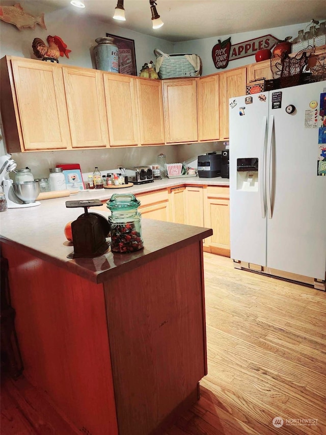 kitchen featuring white fridge with ice dispenser, light brown cabinets, and light wood-type flooring