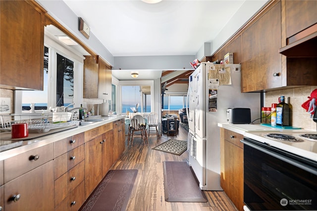 kitchen with white appliances, dark hardwood / wood-style flooring, and decorative backsplash