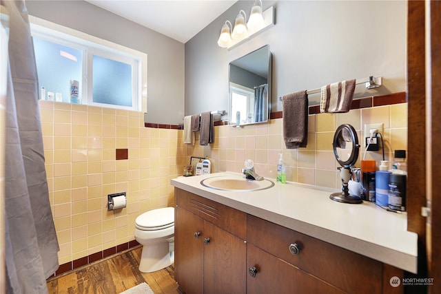 bathroom featuring tile walls, toilet, hardwood / wood-style flooring, and vanity