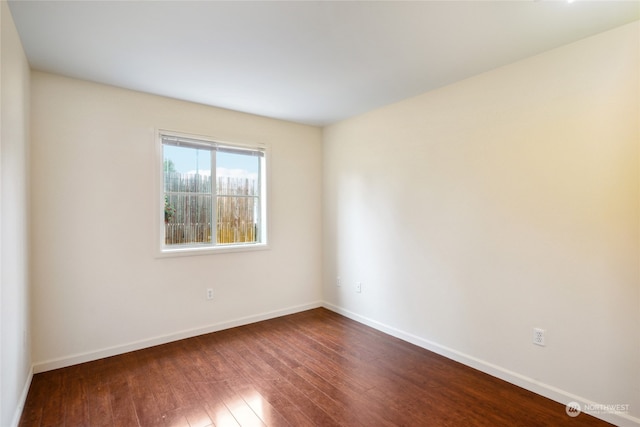 unfurnished room with dark hardwood / wood-style flooring