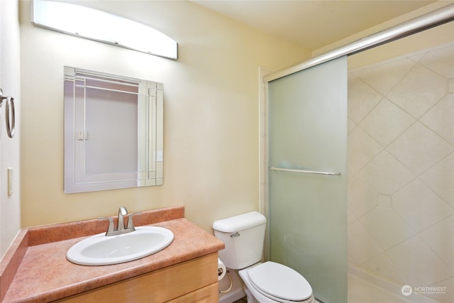 bathroom featuring vanity, toilet, and an enclosed shower