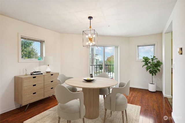 dining space with an inviting chandelier, plenty of natural light, and dark hardwood / wood-style floors