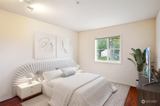 bedroom with dark hardwood / wood-style flooring