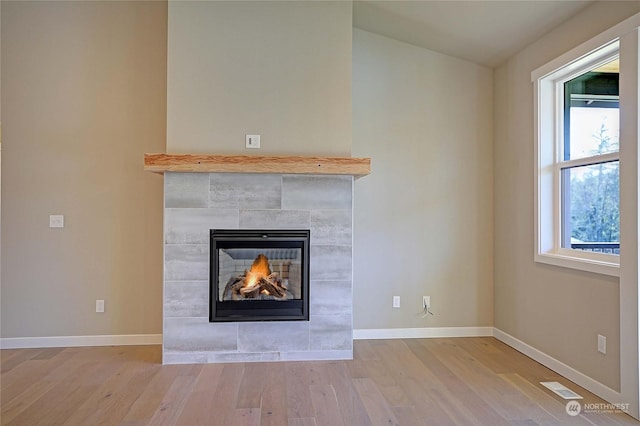 details featuring wood-type flooring and a tile fireplace