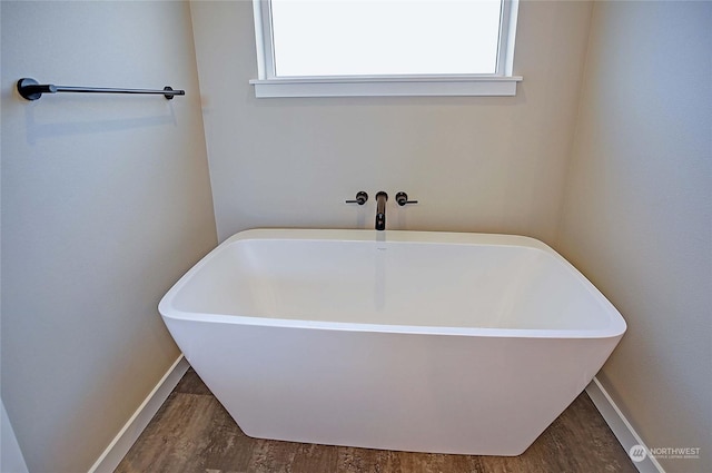 bathroom with a tub and hardwood / wood-style floors