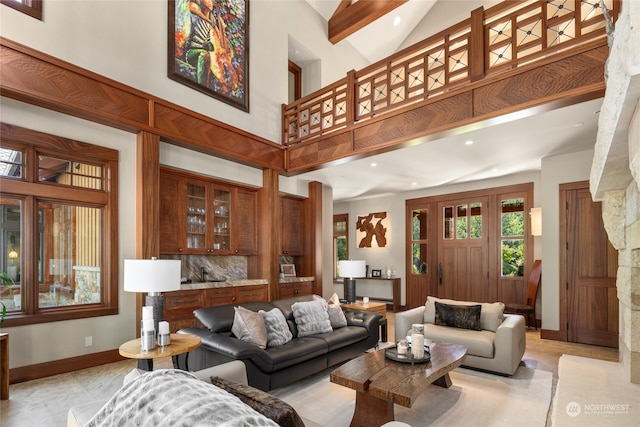 living room featuring beamed ceiling and a high ceiling