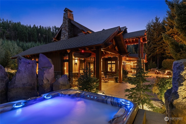 pool at dusk featuring a patio