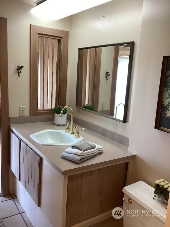 bathroom featuring tile patterned flooring, vanity, and toilet