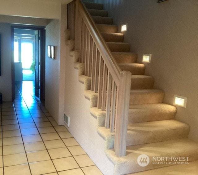 stairway with tile patterned flooring