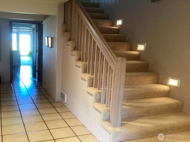 stairway featuring tile patterned flooring