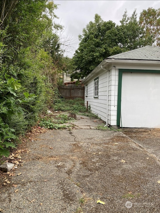 view of side of home featuring a garage and an outbuilding