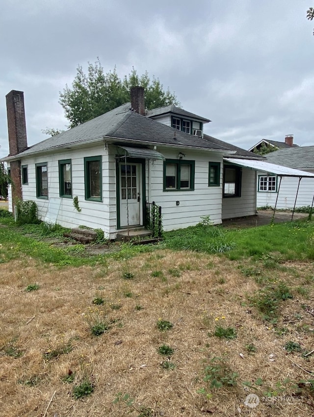 rear view of house featuring a lawn