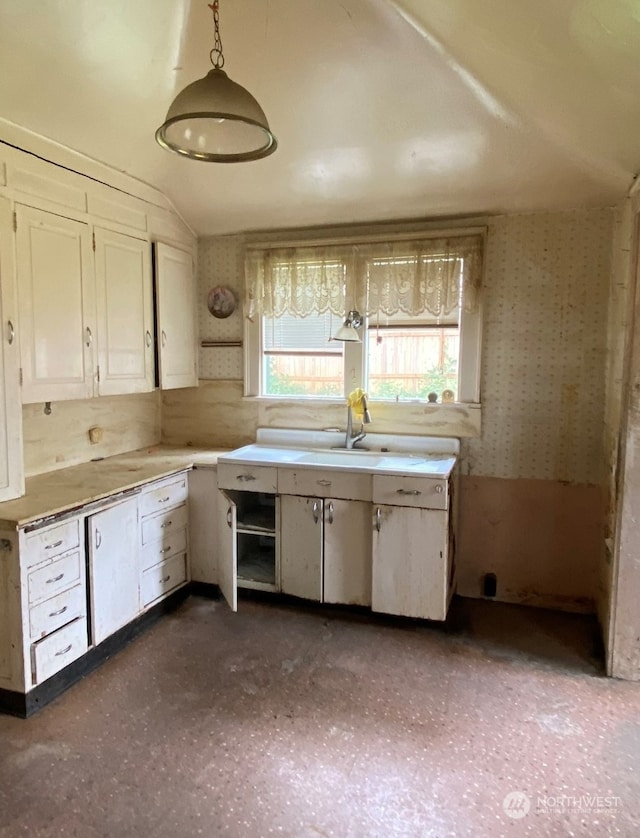 kitchen with sink, backsplash, hanging light fixtures, and vaulted ceiling