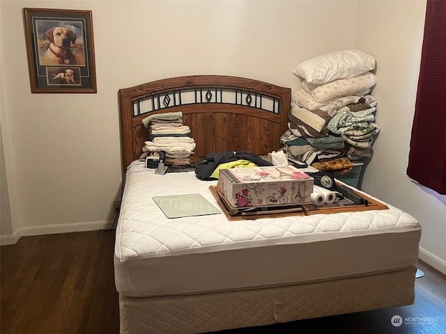 bedroom with dark hardwood / wood-style floors