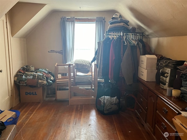 additional living space featuring hardwood / wood-style floors, a textured ceiling, and vaulted ceiling