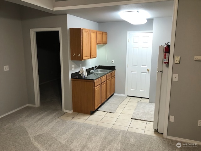 kitchen with sink, light colored carpet, and white fridge