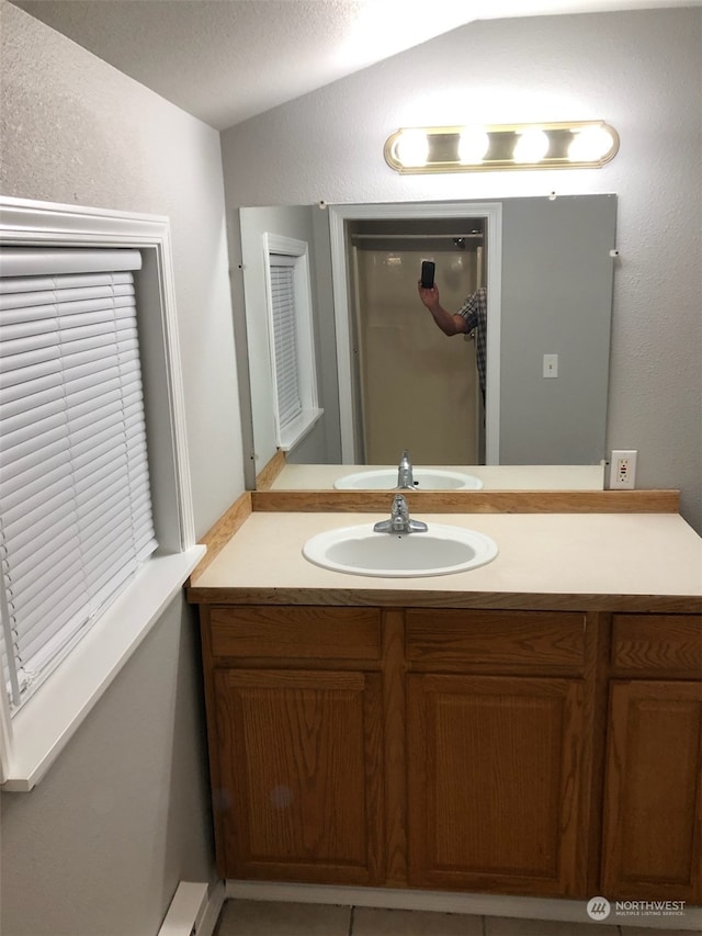 bathroom with vanity, a textured ceiling, and vaulted ceiling