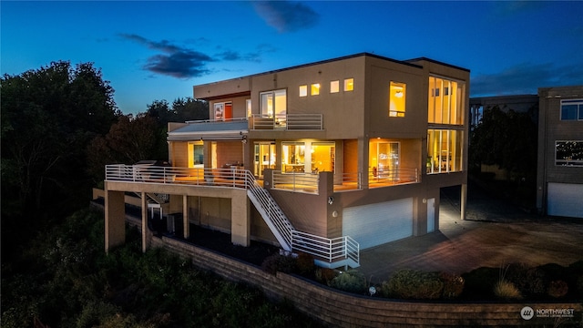 back house at dusk featuring a garage