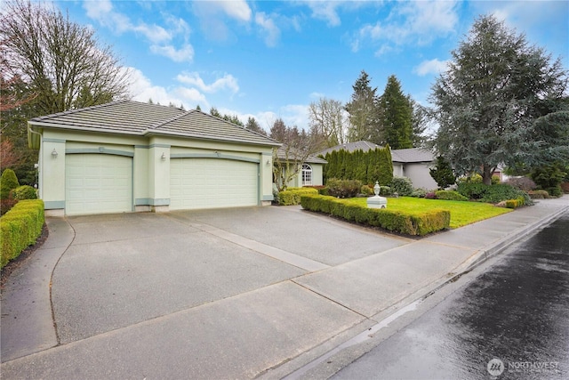 single story home with a garage, concrete driveway, a tiled roof, a front lawn, and stucco siding