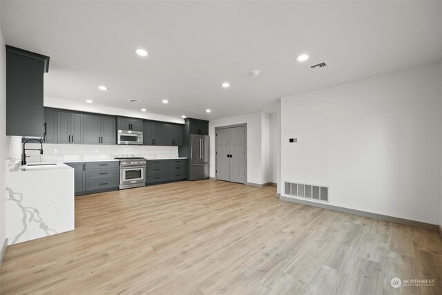 kitchen featuring stainless steel appliances, sink, and light hardwood / wood-style floors