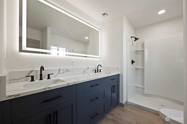 bathroom with vanity, toilet, hardwood / wood-style flooring, and walk in shower