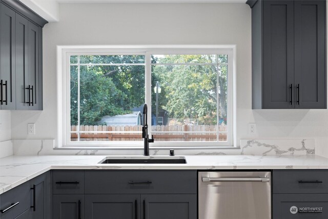 kitchen with gray cabinets, light stone countertops, and sink