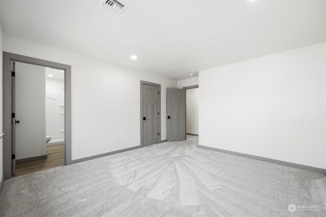 interior space with connected bathroom and light carpet