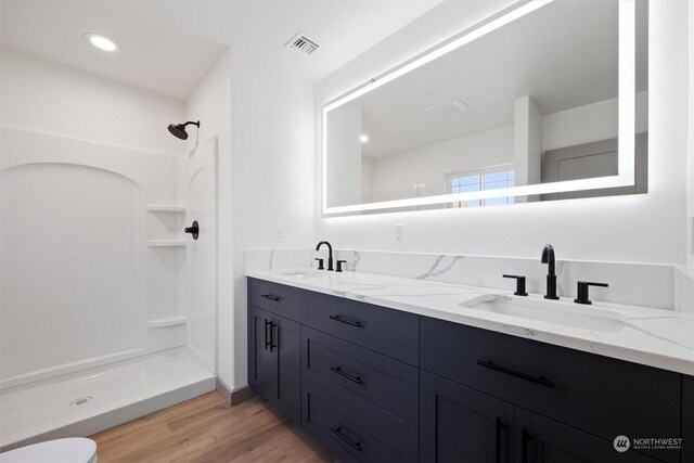 bathroom with vanity, toilet, wood-type flooring, and walk in shower