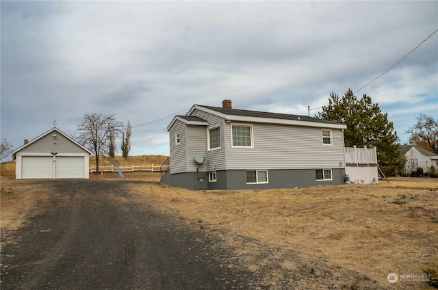 view of side of home with an outdoor structure and a garage