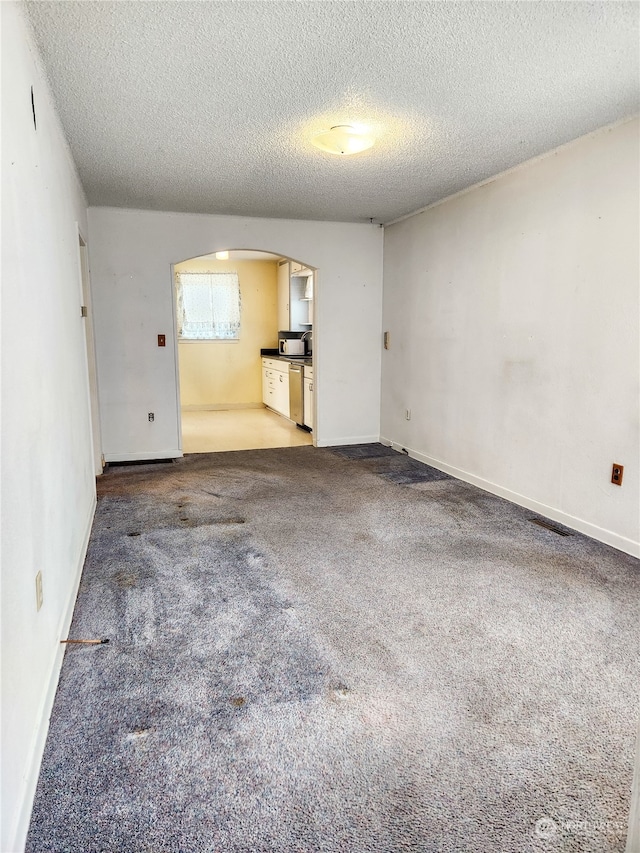 interior space with a textured ceiling and carpet floors