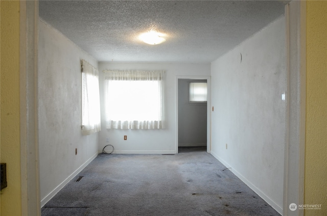 unfurnished room featuring carpet floors and a textured ceiling