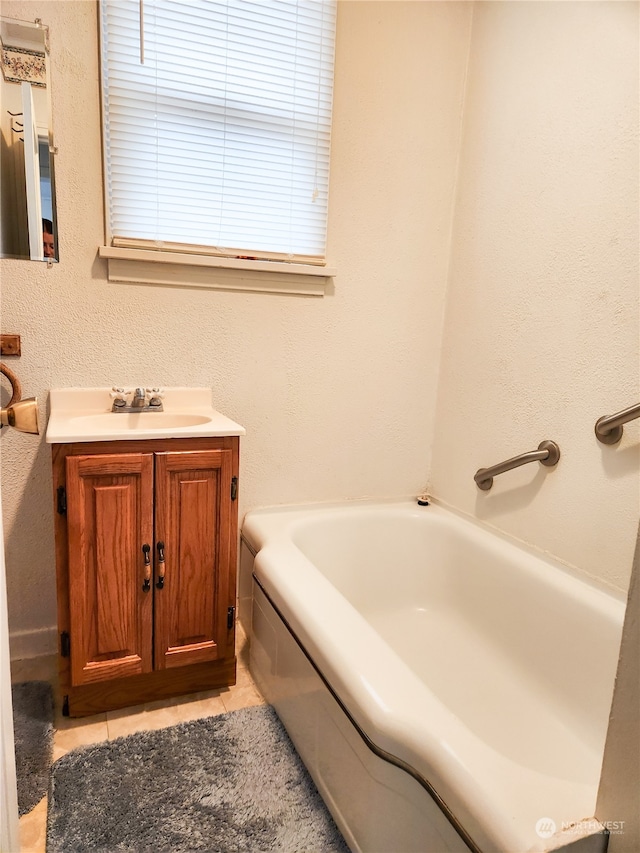 bathroom with vanity, a bathtub, and tile patterned flooring