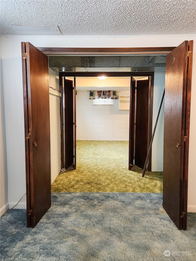 hallway with a textured ceiling and carpet